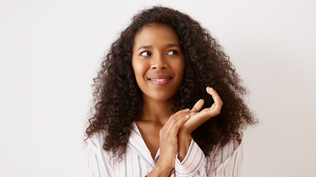 Young dark skinned female with long voluminous hair feeling excited full great interesting ideas rubbing hands looking sideways