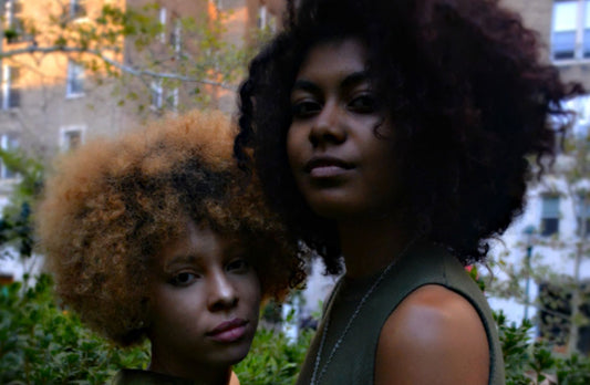 Two women with black curly hair