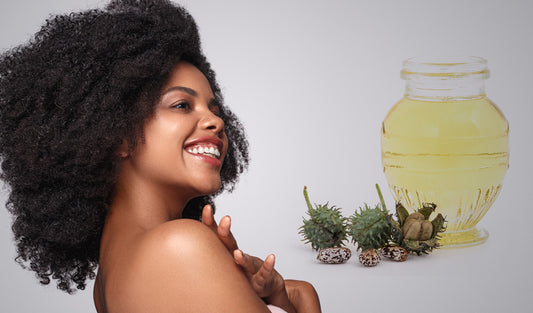 Woman smiling with healthy, curly hair next to castor oil